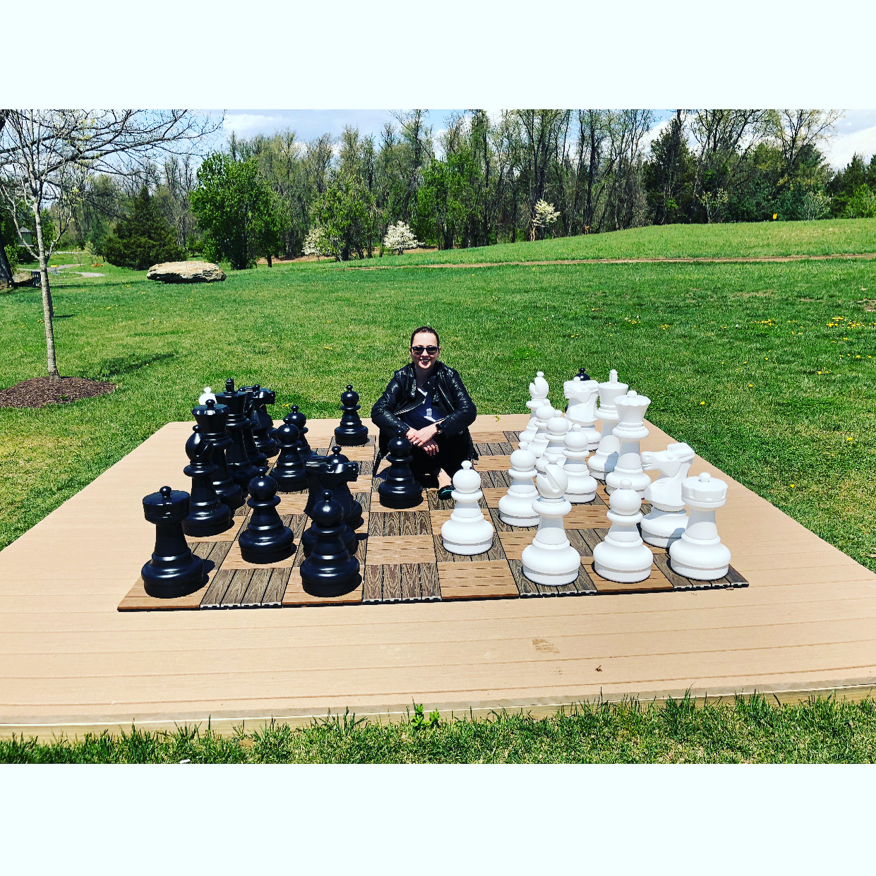 large outdoor chess board woman sitting