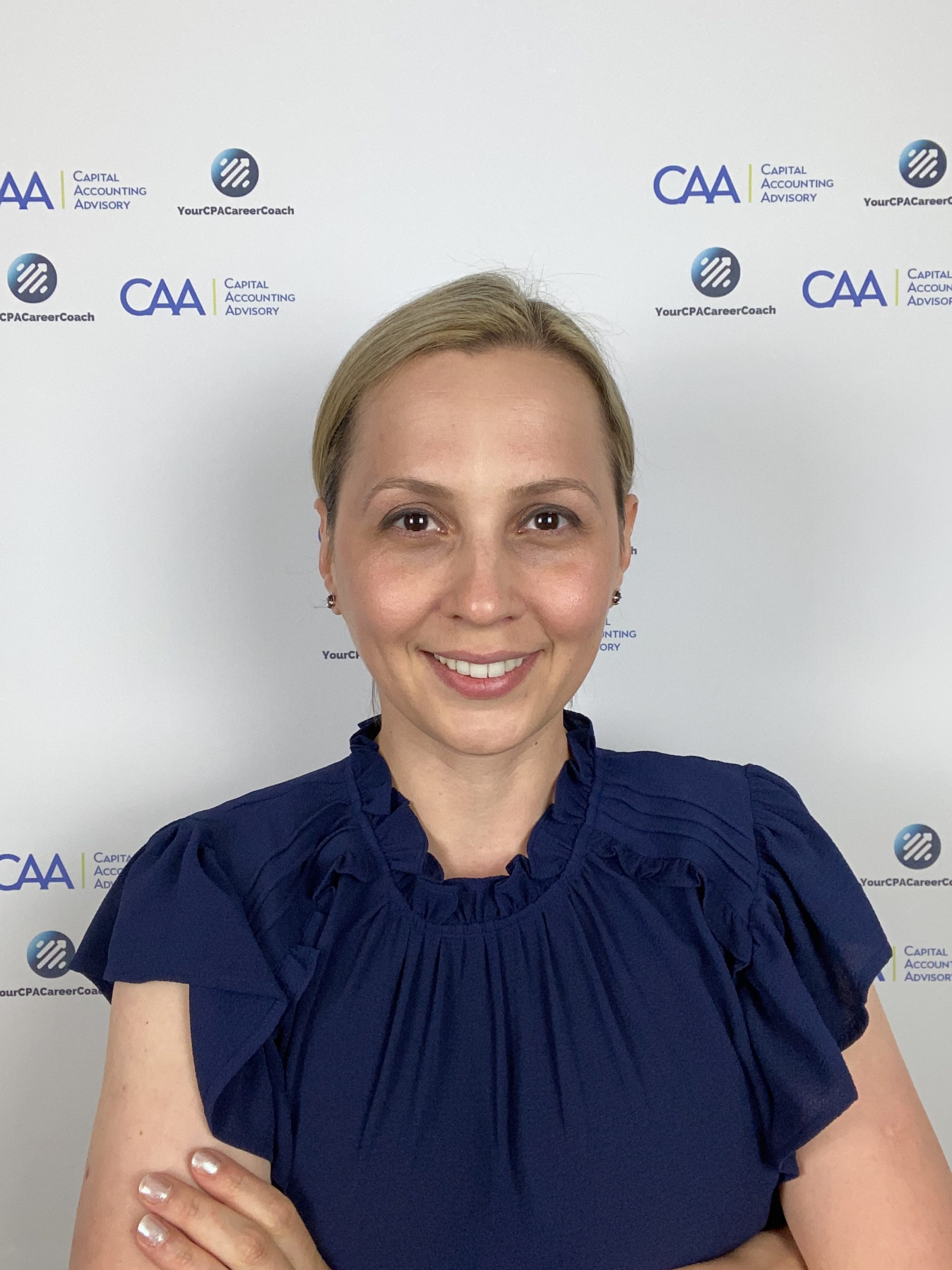 a woman standing in front of a corporate banner